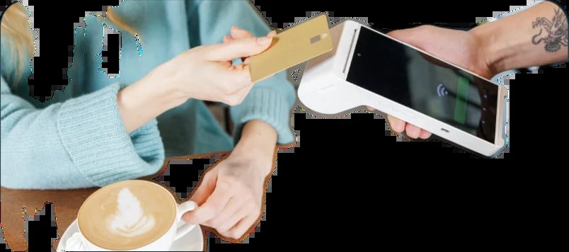 Two people holding a tablet and credit card over a coffee cup, depicting a contactless payment transaction